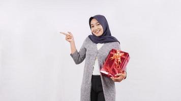 asian girl carrying a gift showing side blank isolated on white background photo