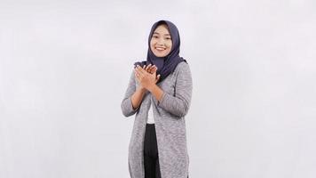 asian woman in hijab smiling while clapping isolated on white background photo