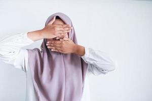 Young Asian Islam women wearing headscarf is covering her face with hand. Islam culture concept photo