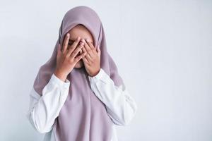 Young Asian Islam women wearing headscarf is covering her face with hand. Islam culture concept photo