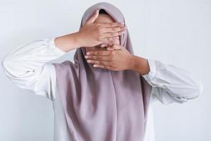 Young Asian Islam women wearing headscarf is covering her face with hand. Islam culture concept photo