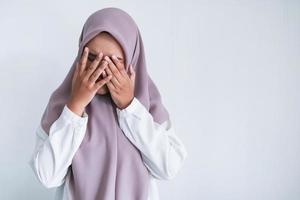 Young Asian Islam women wearing headscarf is covering her face with hand. Islam culture concept photo