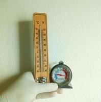 Gloved hand hold analog and digital fridge thermometer to monitoring laboratory temperature, Thermal detector photo