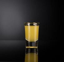 shot glass with alcohol on a dark background photo