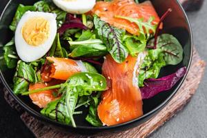 salad salted salmon, eggs, green lettuce fresh portion healthy meal pescatarian diet photo