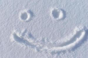 una cara sonriente en la nieve en invierno foto