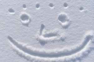 A smiling face in the snow in winter photo
