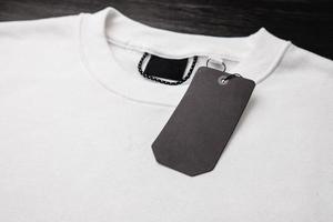 Empty black label on white sweatshirt for logo, size and price. photo