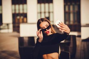 portrait of a attractive woman holding a smartphone digital camera photo
