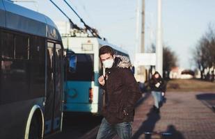 People wearing surgical mask standing at the bus stop photo