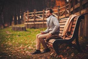 handsome man sitting in bench photo