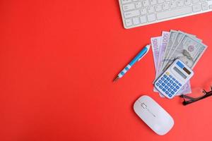 un cuaderno en blanco con bolígrafo se coloca en una mesa de oficina con herramientas informáticas y una variedad de materiales. antecedentes financieros y bancarios, endecha plana, vista superior foto