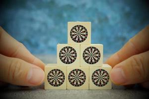 Wood block with dart arrow lands in the dartboards target center, business growth and successful photo