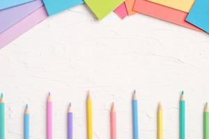 top view of pastel color pencil and file on white table photo