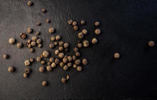 Black peppercorns on table photo