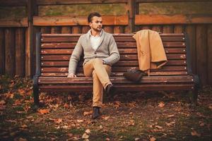 Handsome young man sitting on the bench photo