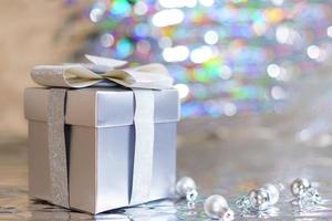 Silver gift box with christmas balls on shiny background photo