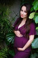 Beautiful pregnant woman feels great in beautiful dress with long flowing hair photo