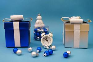 boxes with gifts and christmas tree blue toys with clock on blue background, photo
