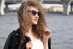 woman close-up portrait in sunglasses on the shore photo