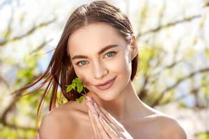 Portrait of a beautiful young woman on a natural background smiling photo