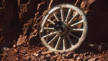 rueda de carreta de madera antigua sobre rocas de piedra foto