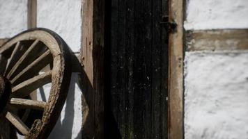 old wood wheel and black door at white house photo