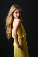 girl  yellow clothes posing on a black background photo