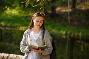 Cute girl in the park with a book in hand photo