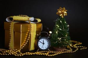 gift box with small christmas tree on black background photo