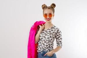 Happy, shock, excited woman face closeup. Girl in bright pink autumn clothes, red sunglasses isolated on white background, copy space. Beautiful female surprised, cheerful. Fun funny model screaming photo