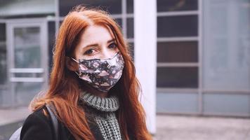 young woman wearing homemade everyday cloth face mask outdoors in city photo