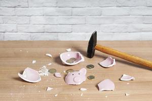 broken Piggy bank smashed into pieces with hammer and small change photo