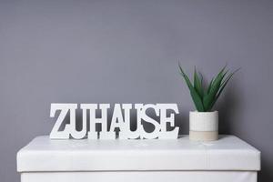 german word zuhause meaning at home as modern interior decoration next to potted plant photo