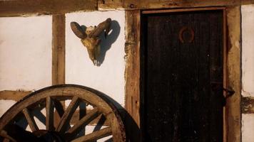 old wood wheel and black door at white house photo