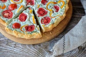 French quiche with tomatoes and pepper and broccoli on wooden Board photo