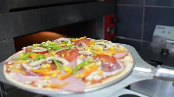 een kok legt pizza in de oven video