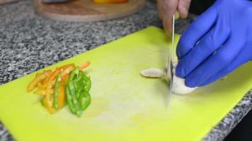 um cozinheiro preparando ingredientes vegetais para uma pizza video
