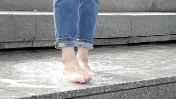 mujer descalza chica piernas jugar con el agua de la fuente de la calle de la ciudad video