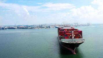 Luftaufnahme des Frachtschiffs, das Container trägt und für Exportgüter vom Frachthafen zum benutzerdefinierten Ozeankonzept-Technologietransport, Zollabfertigung läuft. video