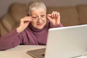 woman sitting in front of laptop communicates online through social networks. Selective focus photo