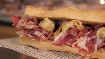 un sándwich con prosciutto de carne italiana y alcachofas - primer plano video