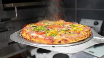 Koch zeigt zubereitete heiße Pizza direkt aus dem Ofen video