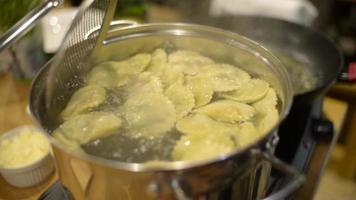 um cozinheiro prepara um ravioli italiano com parmesão em uma cozinha de restaurante video