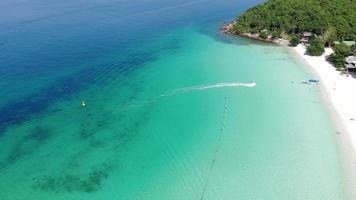 bovenaanzicht vanuit de lucht van en prachtig zeestrand bij bovenaanzicht op de zomer, luxe eilandparadijs voor toerismereizen op zomervakantie. video