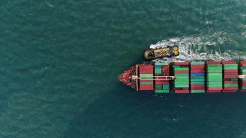 Aerial top view smart cargo ship carrying container running directions for export import near  cargo yard port concept freight shipping by cargo ship .