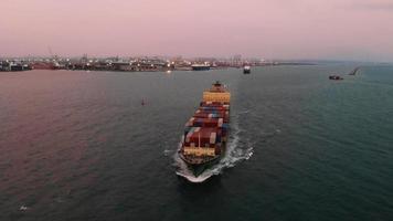 luftaufnahme des frachtschiffes, das container trägt und mit schlepperboot für exportgüter auf dem muschelmeer vom frachthofhafen zum benutzerdefinierten ozeankonzept läuft frachtversand per schiff. video