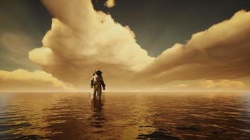 Spaceman in the sea under clouds at sunset photo