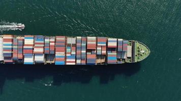 Aerial top view smart cargo ship carrying container running directions for export import near  cargo yard port concept freight shipping by cargo ship .