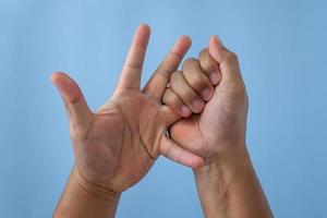 Office syndrome concept. Ring finger is massaged and stretched after working. Close up shot isolate on blue background. Forehand view. photo